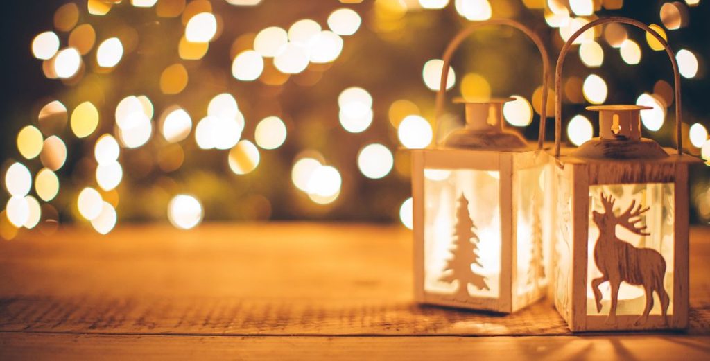 tree and deer shapes in lanterns in front of holiday lights