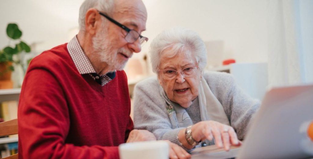 elderly couple working on laptop